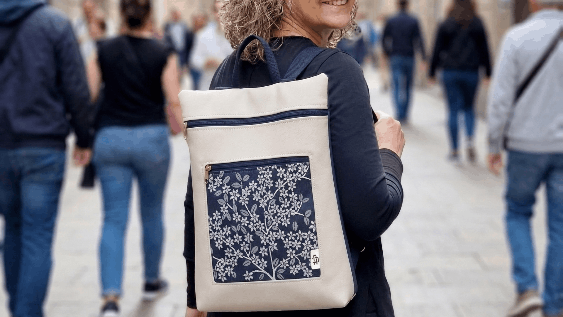 Mujer caminando por calle llevando una mochila antirrobo para ordenador de Cristina Alba