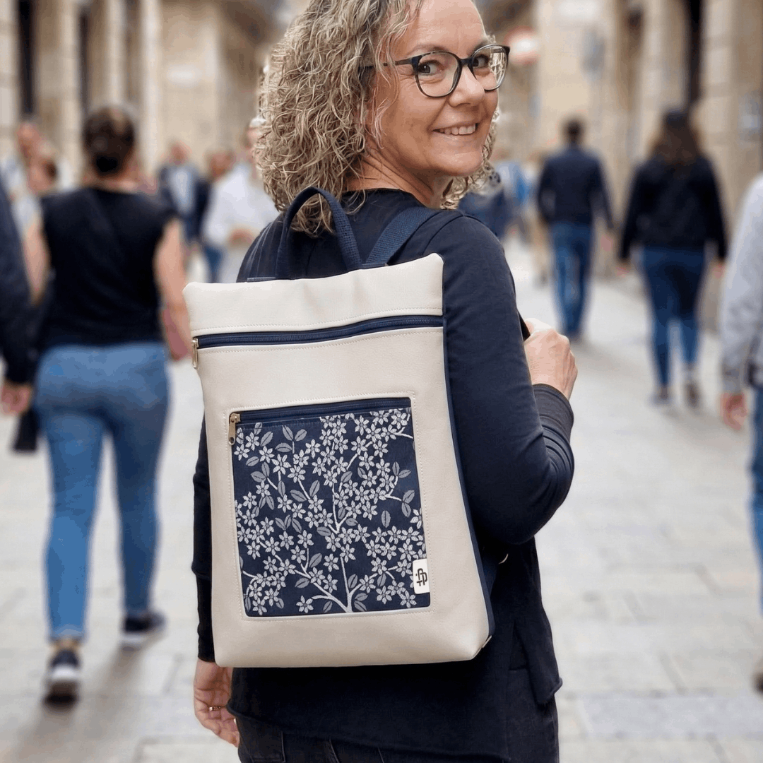 Mujer sonriendo llevando una mochila antirrobo reversible de Cristina Alba