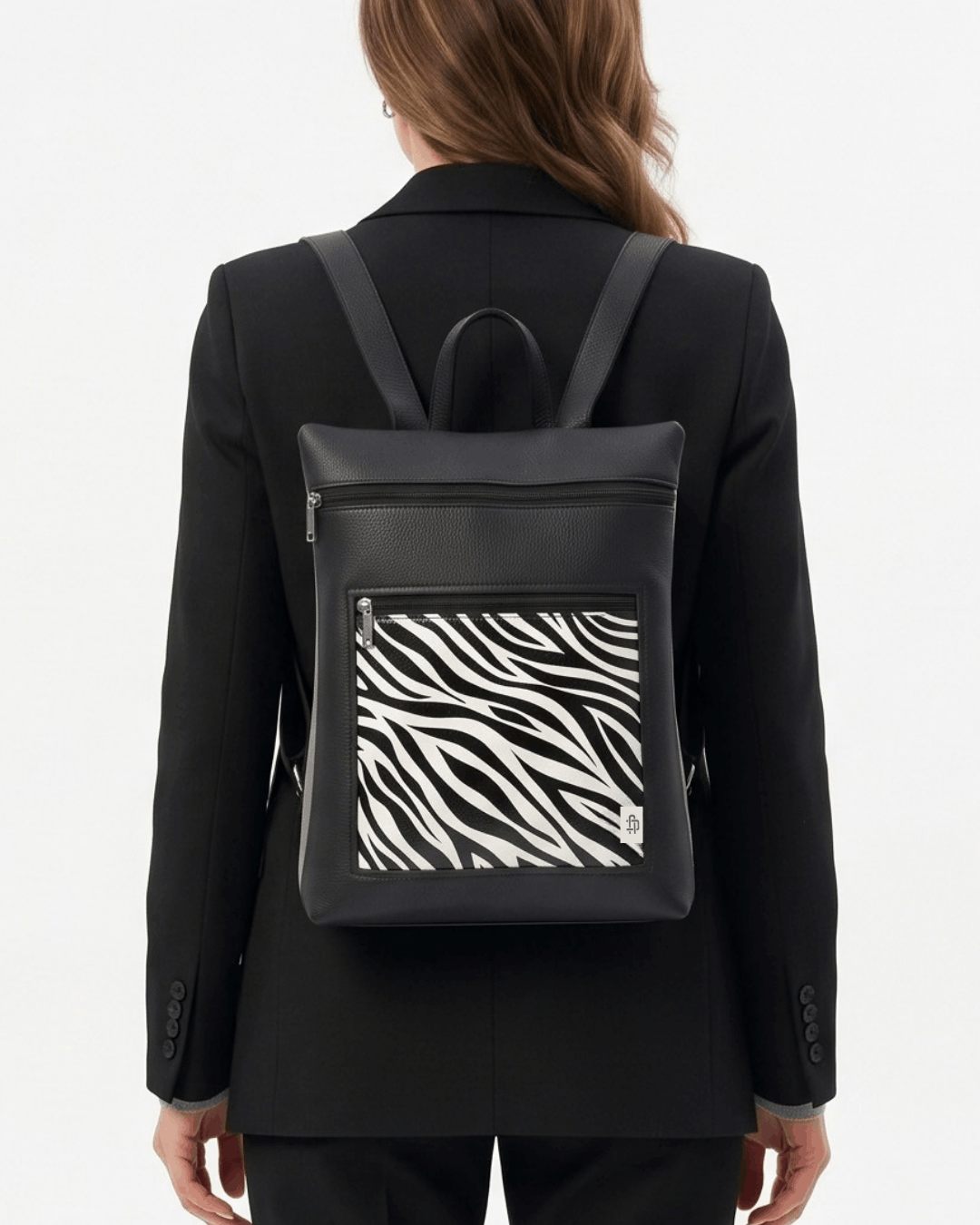 MUJER CON MOCHILA ANTIRROBO REVERSIBLE COLOR NEGRO ANIMAL PRINT DE CRISTINA ALBA