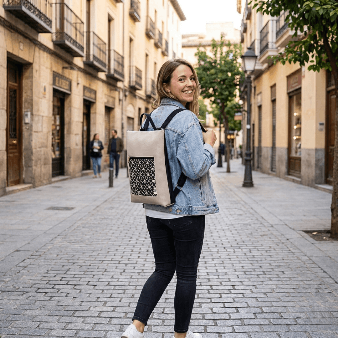 mujer-sonriente-llevando-mochila-antirrobo-geometrico-gris-negro-cristina-alba