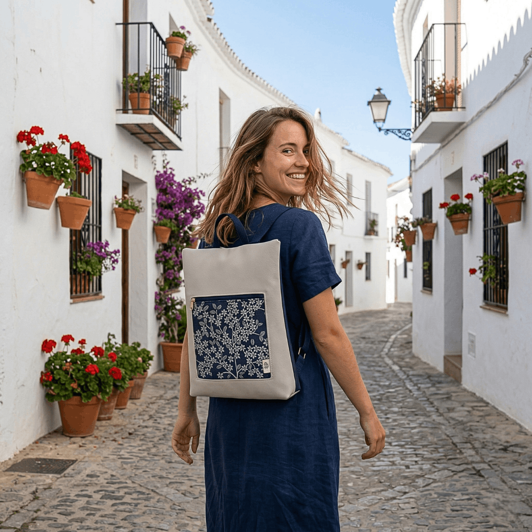 mujer-sonriente-llevando-mochila-antirrobo-indigo-ceniza-marino-cristina-alba