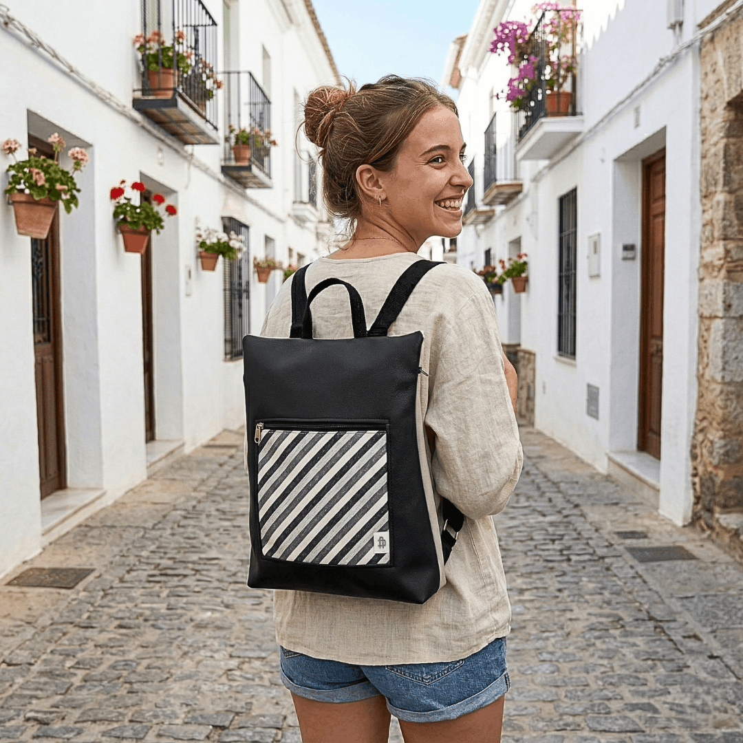 mujer-sonriente-llevando-mochila-antirrobo-rayas-negro-cristina-alba