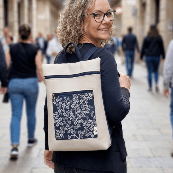 Mujer sonriendo llevando una mochila antirrobo reversible de Cristina Alba